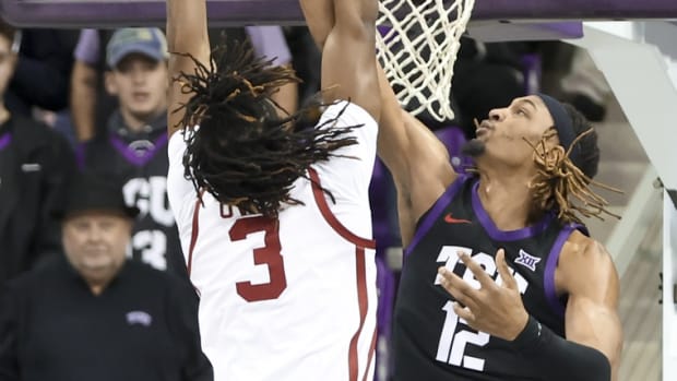 Jan 24, 2023; Fort Worth, Texas, USA; TCU Horned Frogs forward Xavier Cork (12) blocks the shot of Oklahoma Sooners guard Otega Oweh (3) during the first half at Ed and Rae Schollmaier Arena.